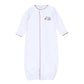 White long-sleeve baby converter gown with deep crimson scalloped trim, front opening, gathered bottom, and embroidered elephant holding a pom detail.