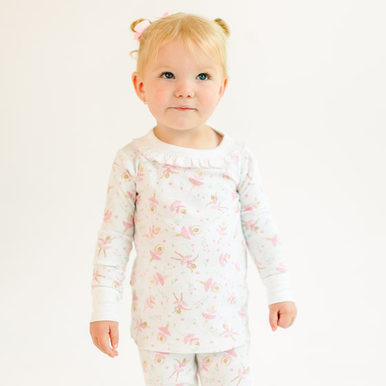 Child wearing a floral ballerina pajama set on a white background