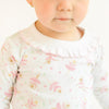 Child wearing a long-sleeve pajama with ballerina design on a white background