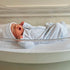 newborn boy in hospital bassinet wearing minicheck footie by magnolia baby in light blue